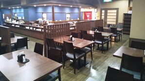 A restaurant with multiple tables and booths, a counter with a menu, and a red sign indicating a restaurant section. - Hotel Route Inn Minokamo (Minokamo)