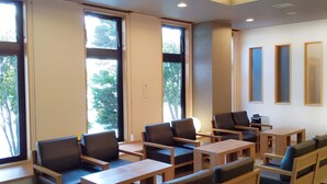 A conference room with multiple tables and chairs, large windows, and a ceiling with recessed lighting. - Hotel Route-Inn Oogaki Inter (Ogaki)