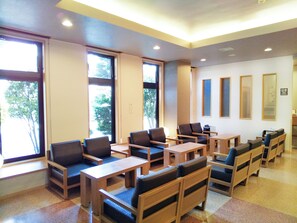 A room with multiple seating areas, large windows, and a ceiling with recessed lighting. - Hotel Route-Inn Oogaki Inter (Ogaki)
