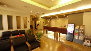 A hotel reception area with a counter, seating, and informational displays. - Hotel Route-Inn Oogaki Inter (Ogaki)
