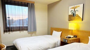 A hotel room with two beds, a desk, a chair, a nightstand with a lamp, a painting, and a window with curtains. - Hotel Route-Inn Oogaki Inter (Ogaki)