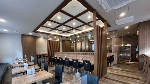 A modern restaurant with wooden flooring, black chairs, and a central bar area. - Hotel Route-Inn Seki (Seki)