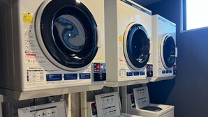 A row of front-loading washing machines in a commercial setting. - Hotel Route-Inn Seki (Seki)