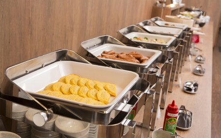 A buffet line with various food items and condiments.