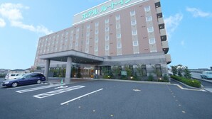 Un hotel con diseño moderno, que presenta un techo plano y un amplio espacio de entrada.