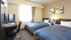 A hotel room with two beds, a desk with a computer and phone, a television, and artwork on the wall.