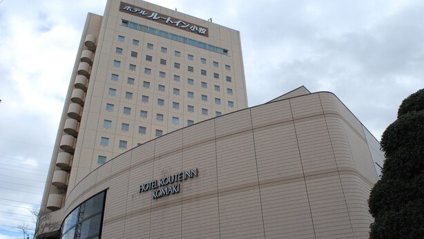 Un hotel dal design moderno, con un cartello ben visibile per HOTEL ROUTE INN KOMAKI.