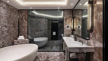 Un baño moderno con una bañera independiente, un espejo grande y un tocador con lavamanos.
