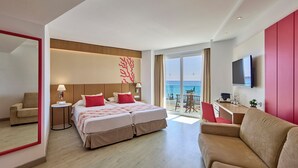 A hotel room with a bed, a sofa, a TV, and a balcony with a view of the sea. - Universal Hotel Perla (Sant Llorenc des Cardassar)