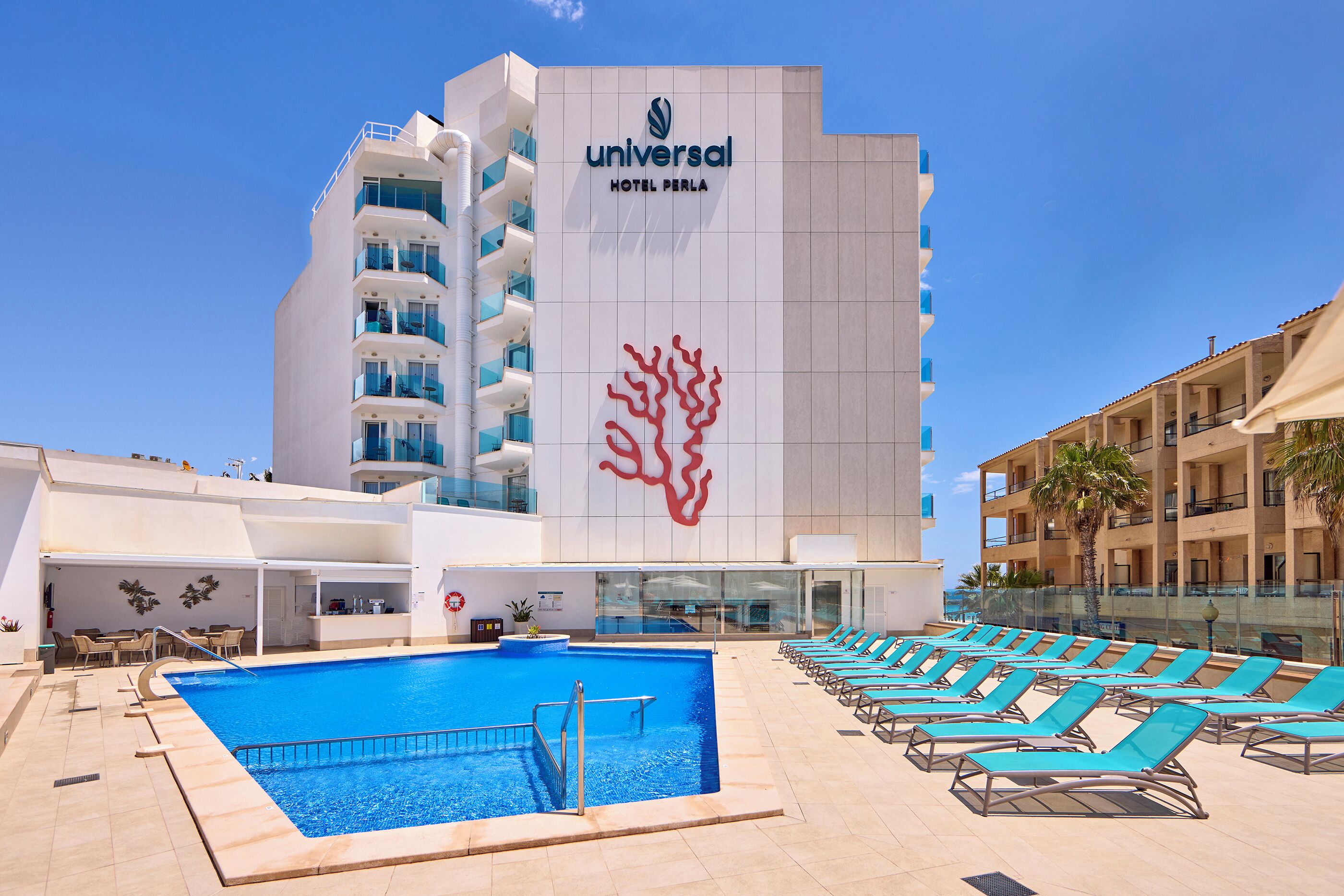 Un hotel con piscina, sillones de descanso y un diseño distintivo de coral en la fachada.