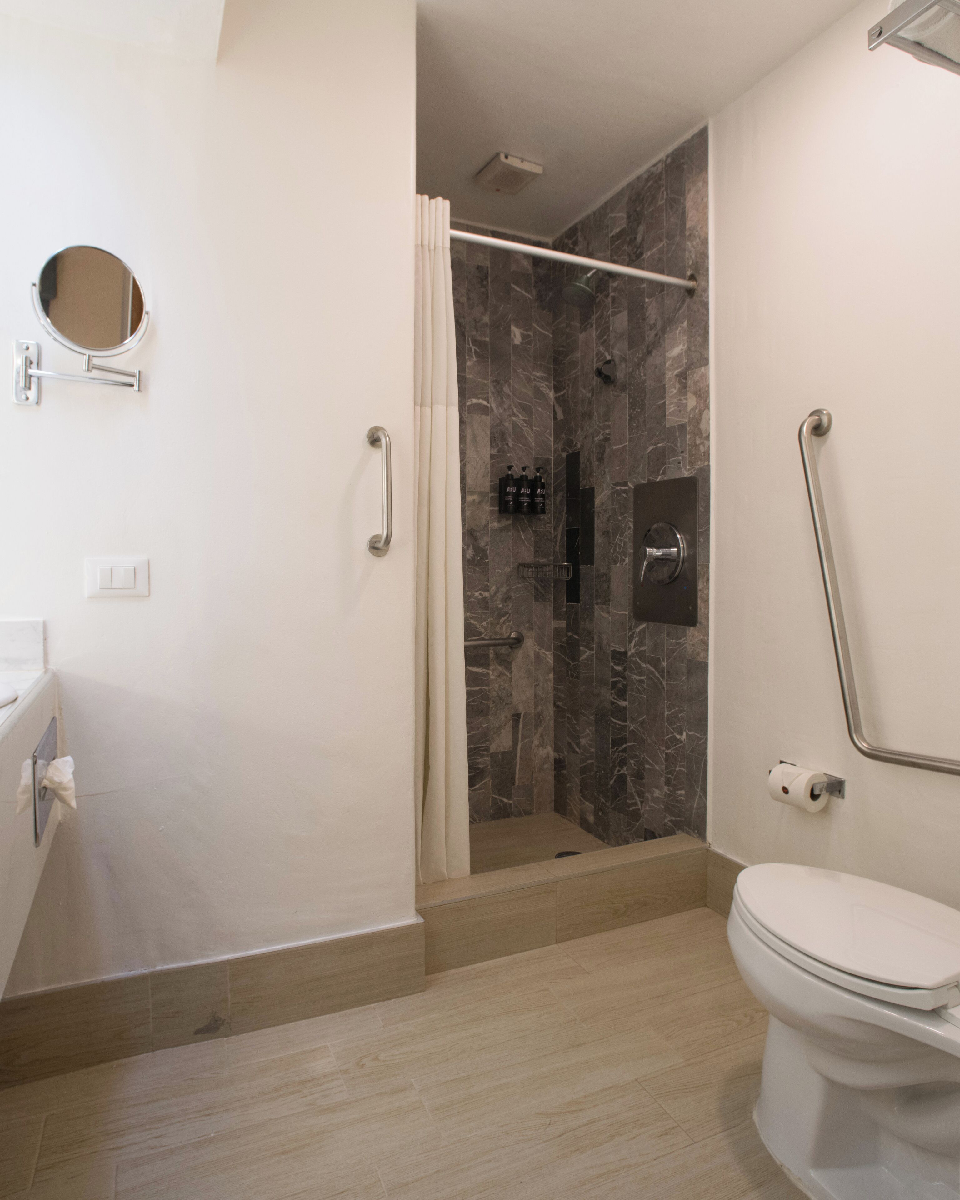 Une salle de bain moderne équipée d’une douche, de toilettes et d’un lavabo.