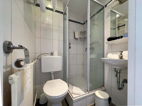 Un baño moderno con inodoro, ducha y lavamanos.