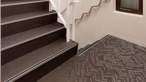 A staircase with a handrail, carpeted steps, and a door with a window. - Hotel New Touhoku (Tokyo)
