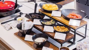 A buffet with various dishes and condiments.
