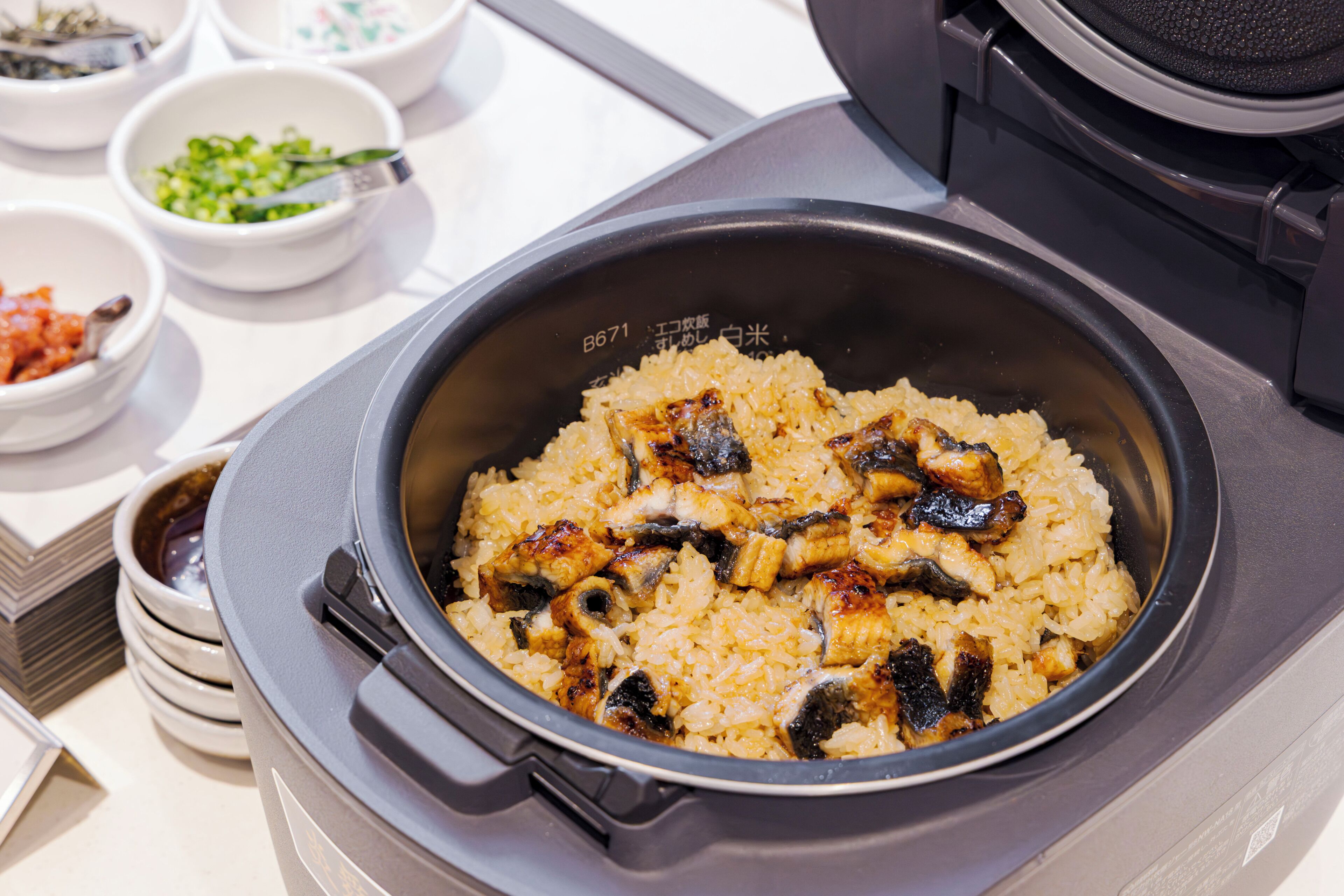 Uma cozinha com um cozinhador de arroz contendo arroz e cogumelos cozidos.