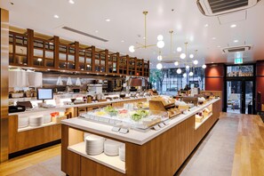 A modern buffet setup with multiple food stations, a wooden counter, and overhead lighting. - Richmond Hotel Nagoya Nayabashi (Nagoya)