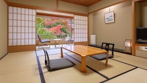 A traditional Japanese room with tatami flooring, a low table, and sliding doors. - Ranzan Hotel (Kyoto)