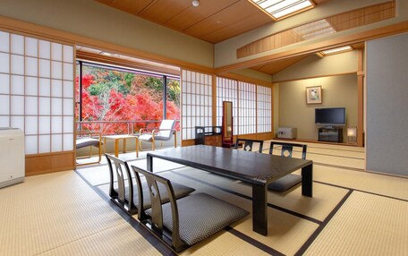A traditional Japanese room with tatami flooring, a low table, and a television.
