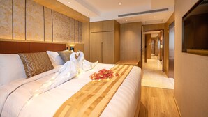 Una habitación de hotel con una cama grande, cabecero de madera y una pared con estampado floral.