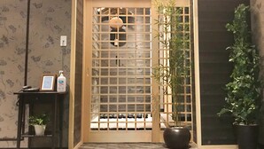 A traditional Japanese room with tatami flooring, a shoji screen door, and a bamboo plant.