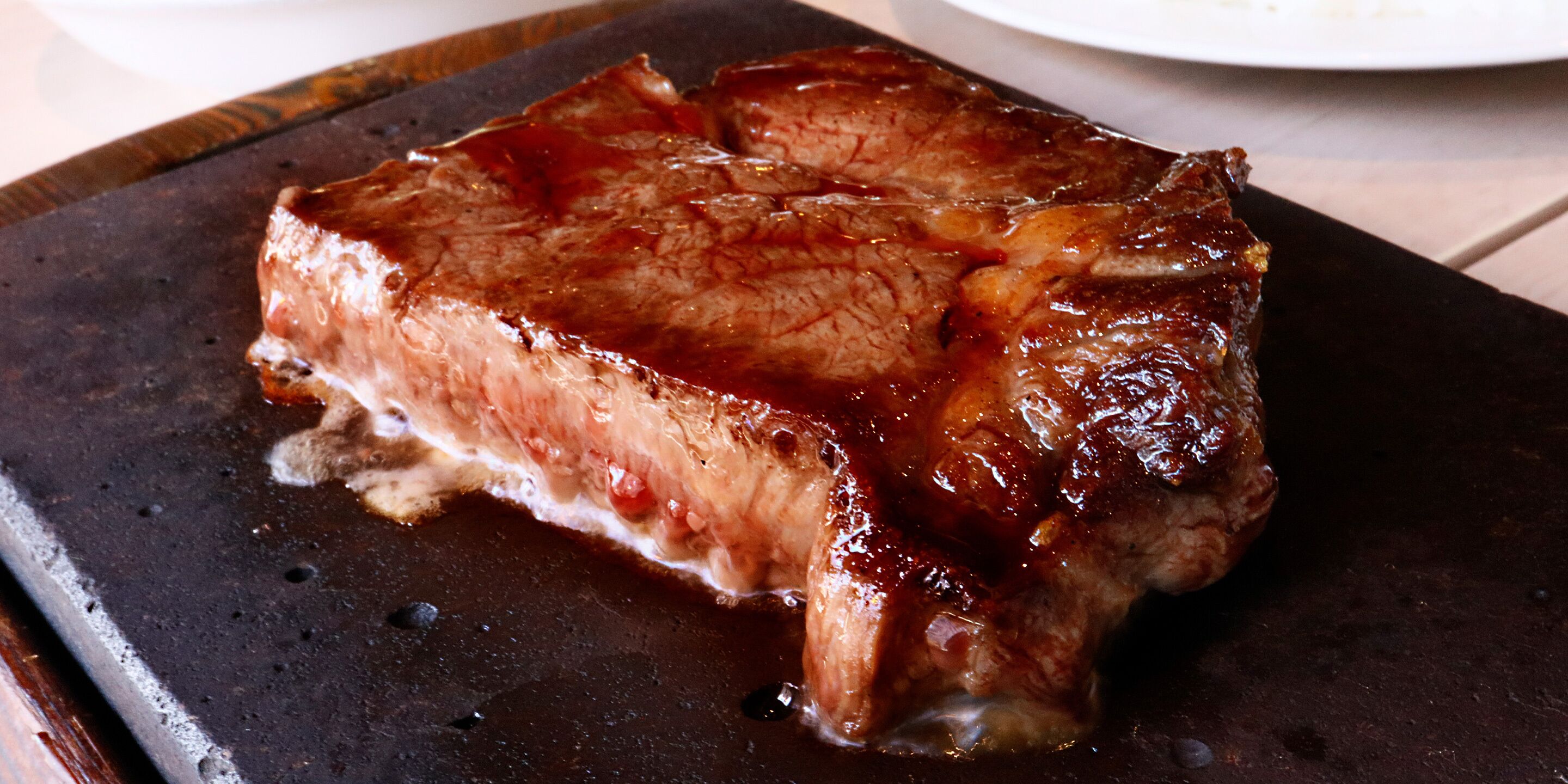 A steak on a dark plate.