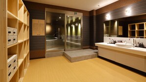 A modern bathroom with a large mirror, a sink, and wooden shelving.