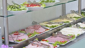 Un buffet proposant une variété de plats et d’ustensiles.