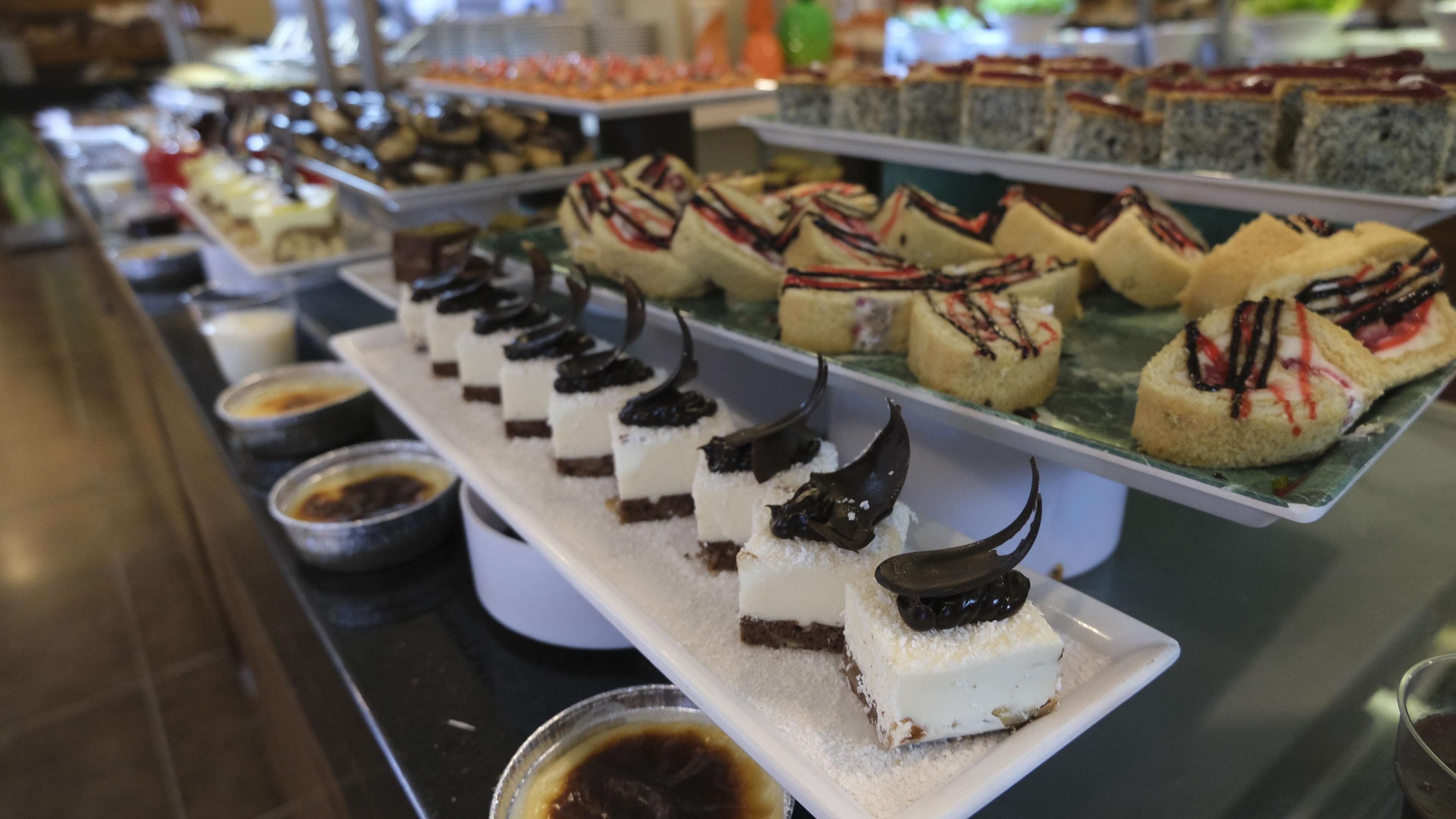 Buffet com diversos doces, incluindo bolos e pastelaria.