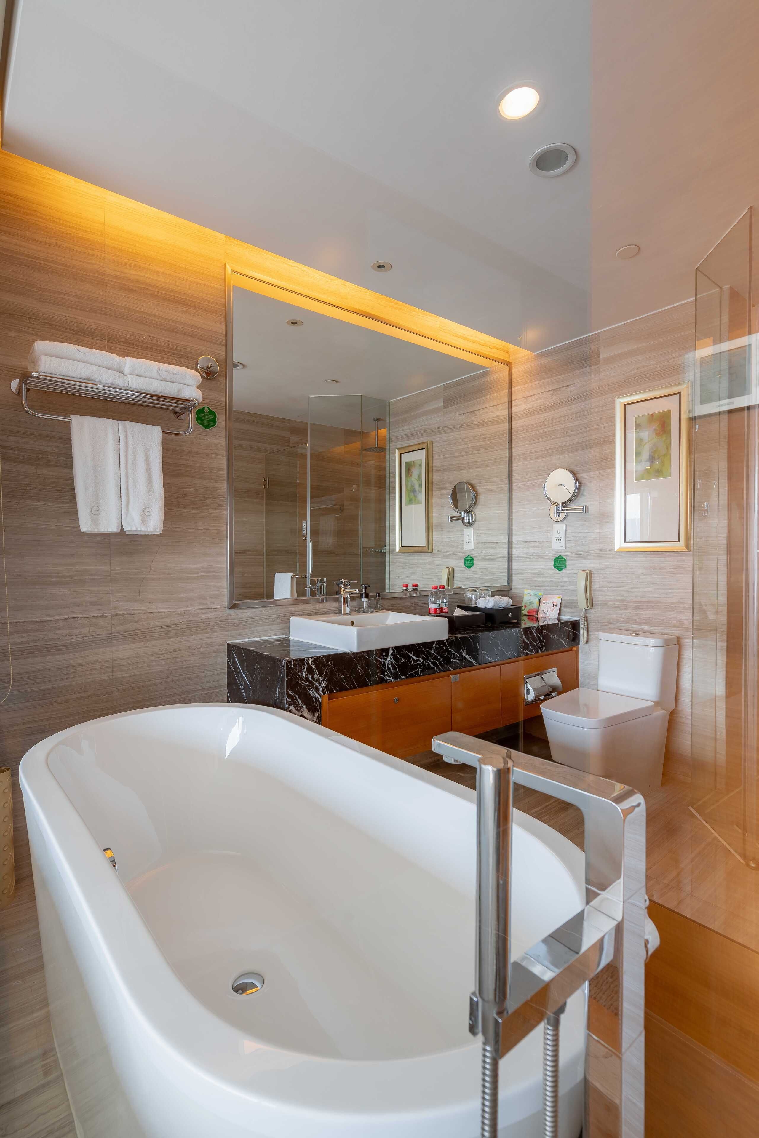 A modern bathroom with a freestanding bathtub, a vanity with a mirror, and a toilet.