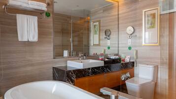 A modern bathroom with a freestanding bathtub, a vanity with a mirror, and a toilet.
