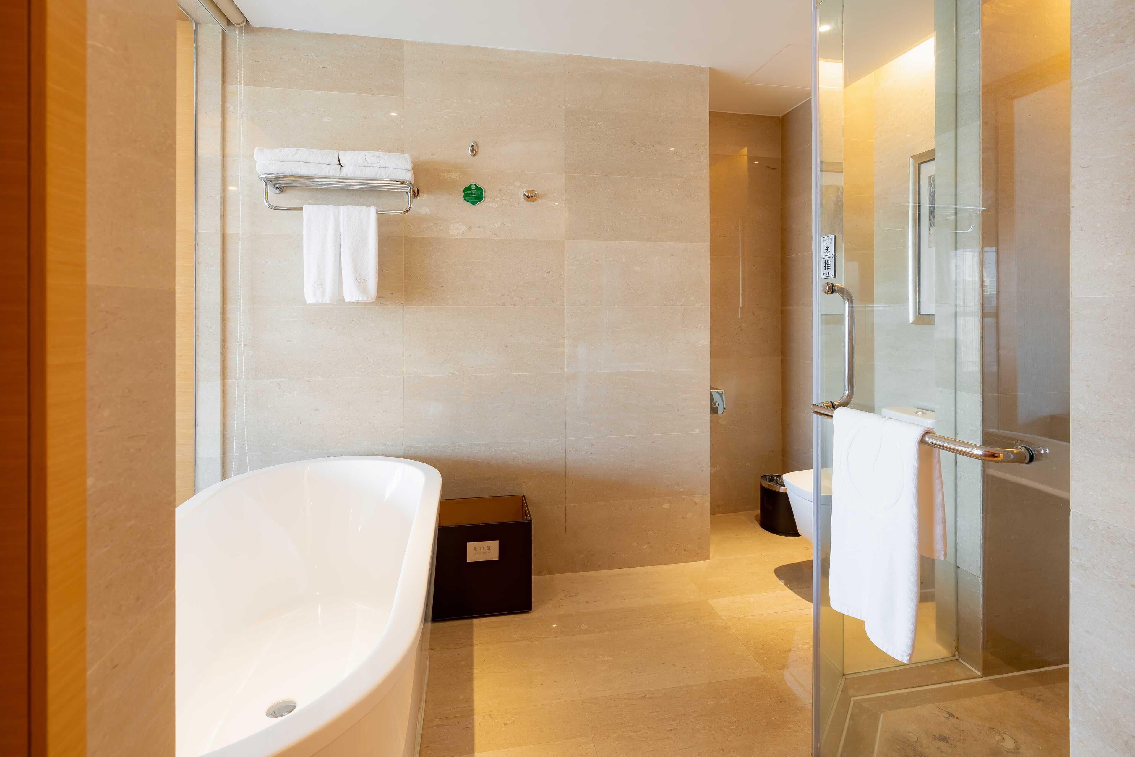 A modern bathroom with a freestanding bathtub, a glass shower enclosure, and a toilet.