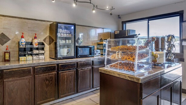 A breakfast bar with a variety of pastries and a coffee station.
