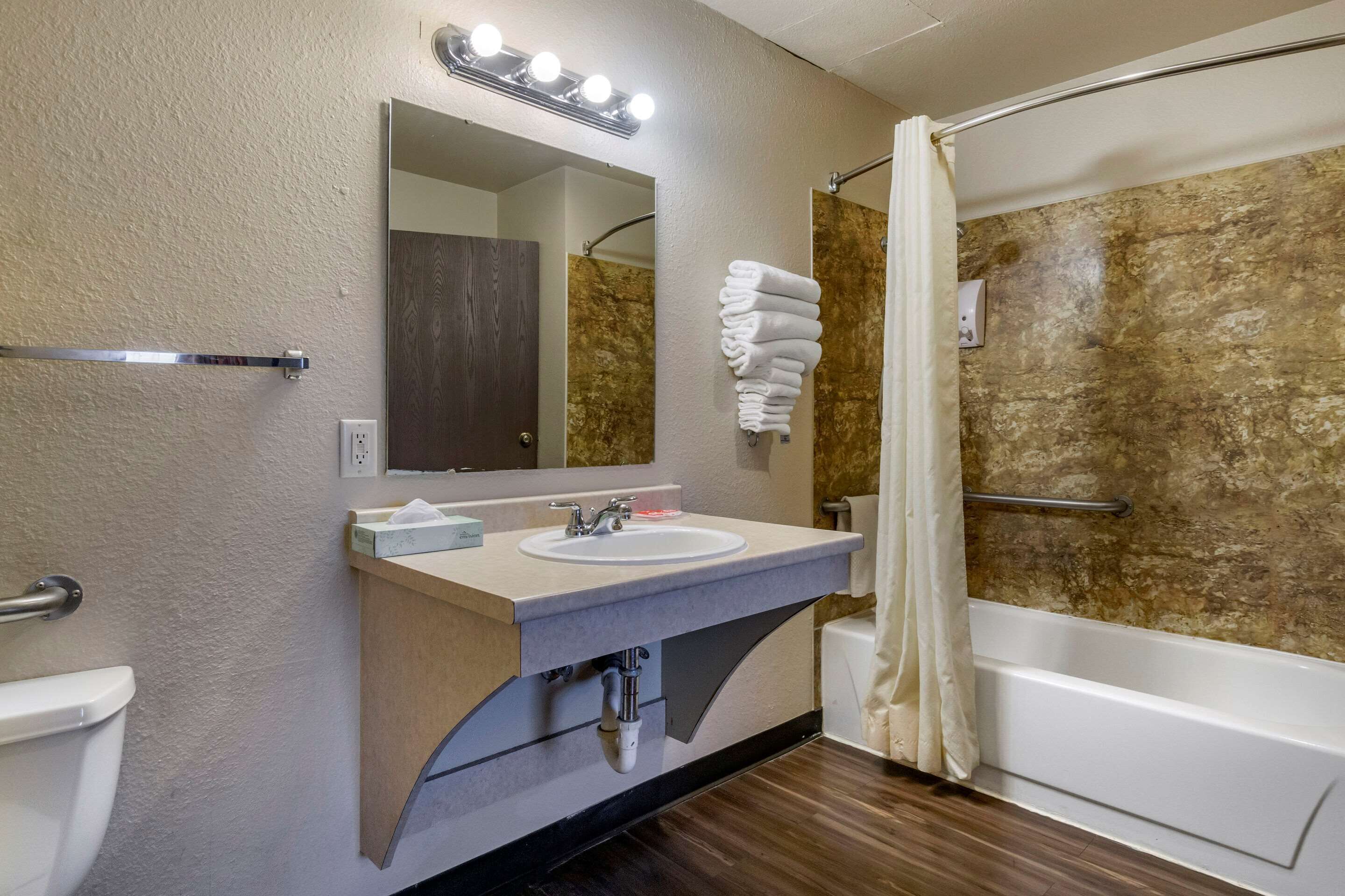 Un baño con lavamanos, espejo y ducha.