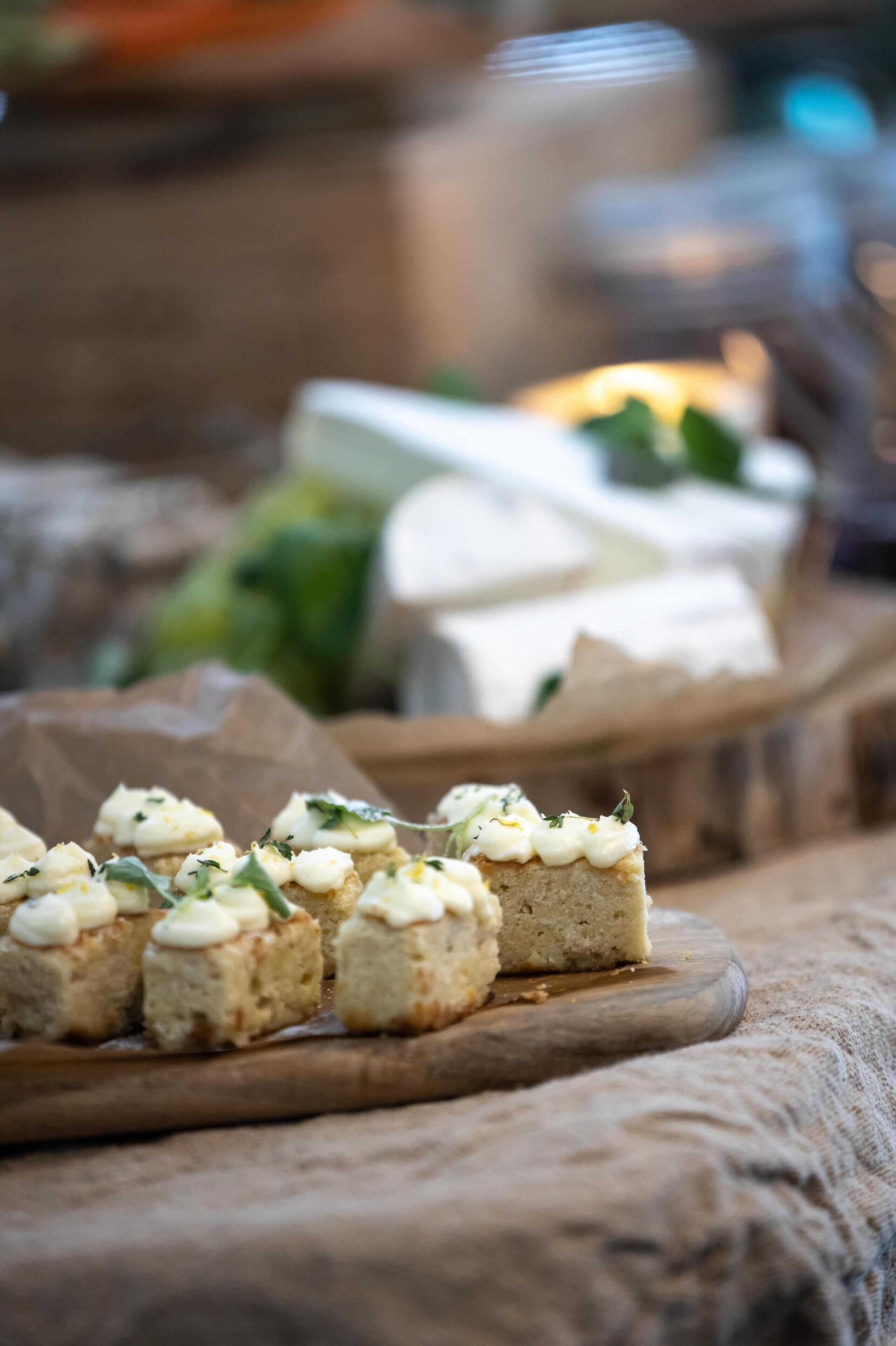 A wooden board with food items, a candle, and a blurred background.