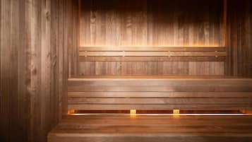 A wooden sauna with benches and a warm light source.