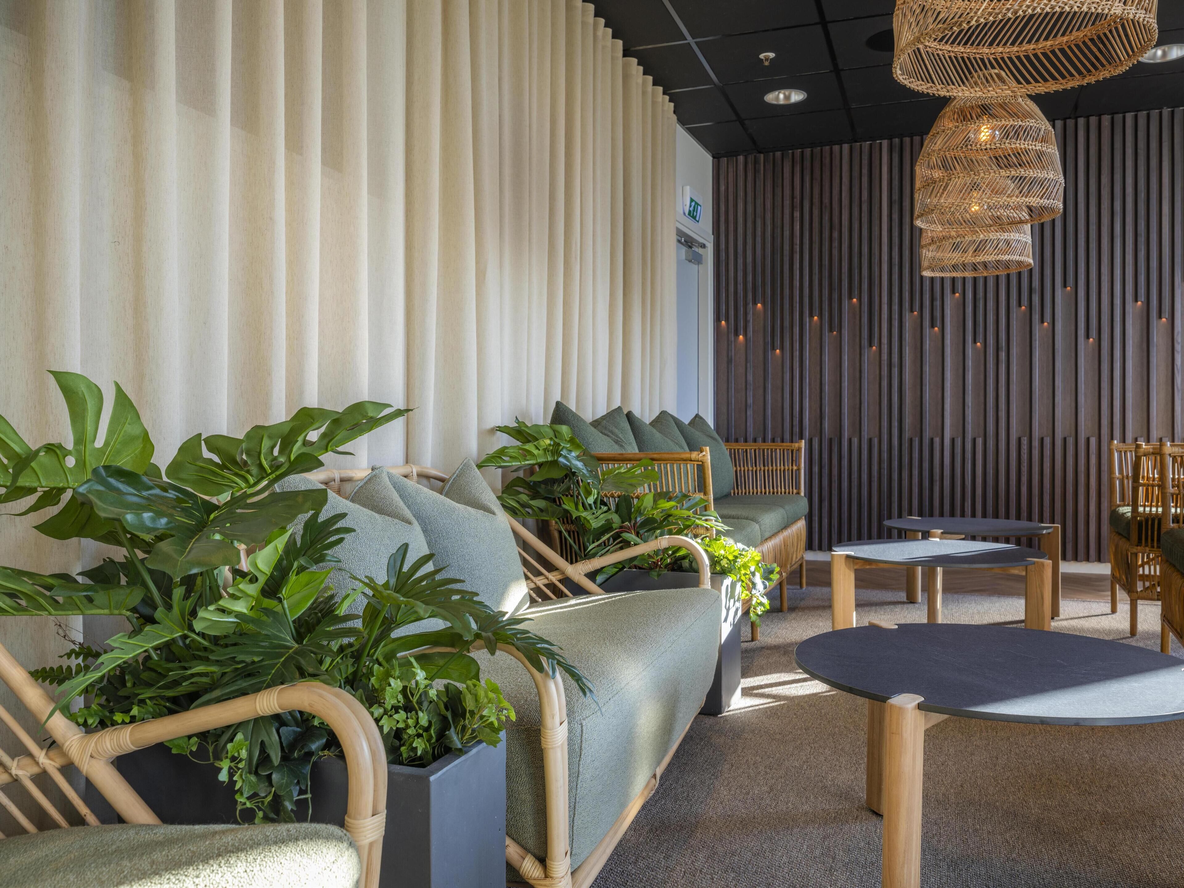 Uma área de estar moderna com um sofá, cadeiras e uma mesa.