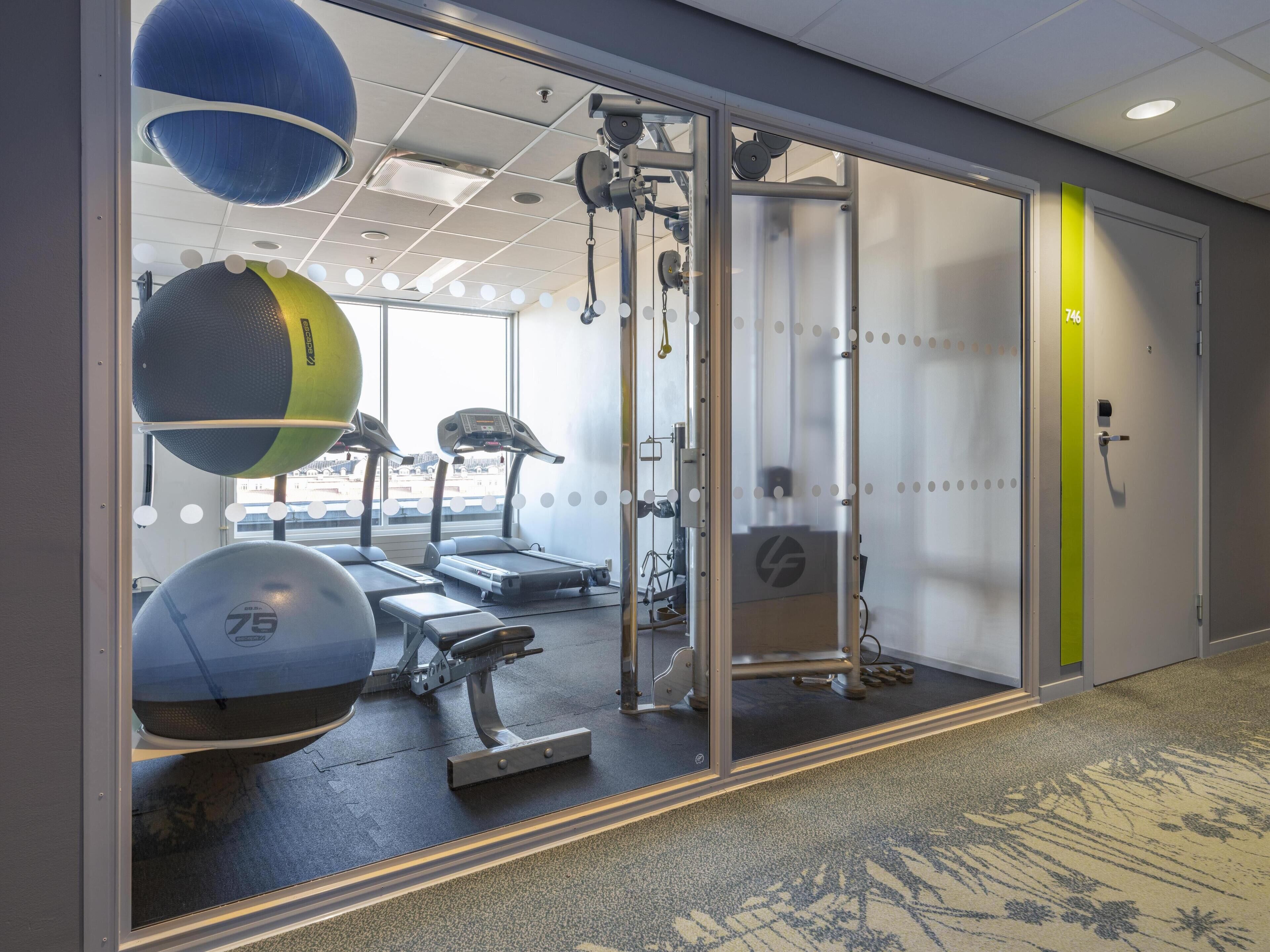 A gym with treadmills, exercise balls, and weight machines.