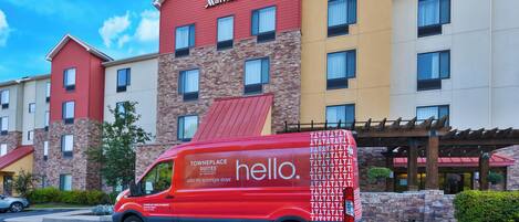 Een TownePlace Suites Marriott hotel met een rode bestelwagen ervoor geparkeerd.