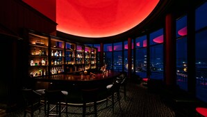 A bar area with a curved ceiling, large windows, and a city view. - Hotel Nord Otaru (Otaru)