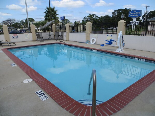 A rectangular swimming pool with a 3 FT depth marking, surrounded by a brick border and a metal ladder.