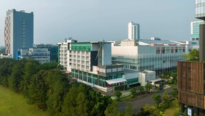 A modern building with multiple floors, large windows, and a mix of glass and concrete facades. - Hotel Santika BSD City Serpong (South Tangerang)