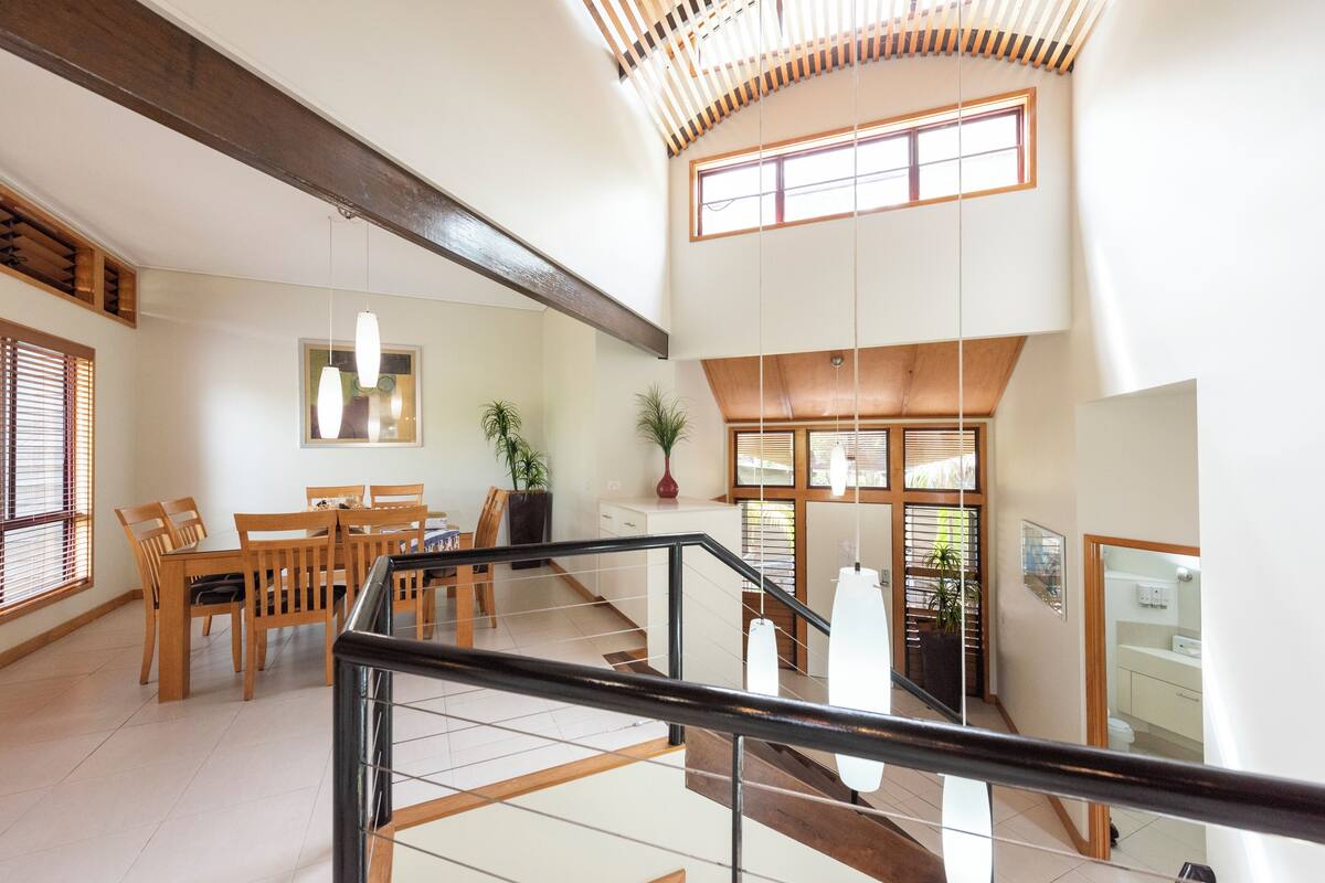 A spacious interior with a dining area, staircase, and a view of the outside.