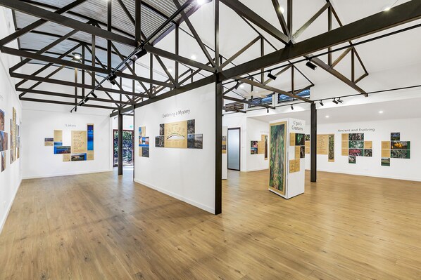 Une galerie d’art dotée de planchers en bois et de poutres apparentes.