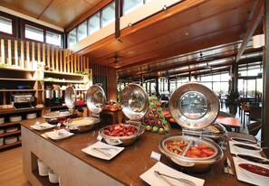 Una barra de buffet con diversos alimentos y utensilios.