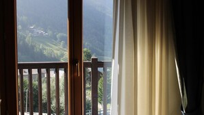 A room with a large window overlooking a mountainous landscape. - Punta Margherita (Valtournenche)