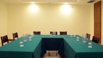 Una sala de conferencias con una larga mesa, sillas y vasos de agua.