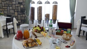 A breakfast buffet with various food items, including fruits, pastries, and beverages. - Hotel Bassetto (Ferentino)