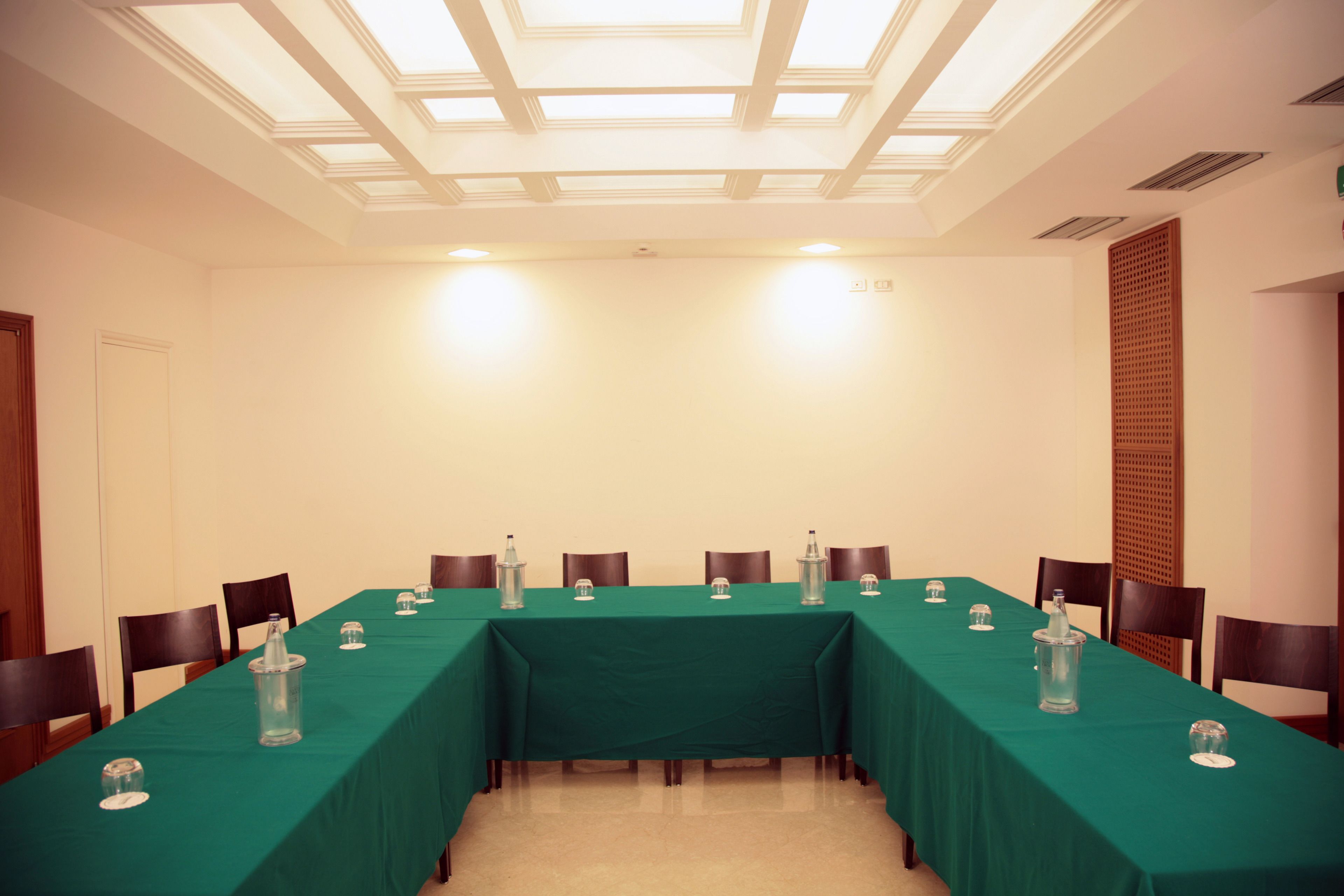 A conference room with a long table, chairs, and a ceiling with skylights.