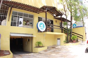 A yellow building with a tiled facade, a sign indicating it is a hotel, and a staircase leading to the entrance. - Hotel Casa de Praia (Fortaleza)