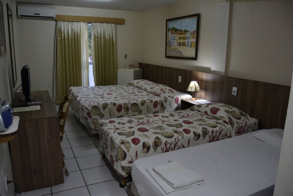 Habitación de hotel con dos camas, un escritorio, una lámpara y un cuadro en la pared.